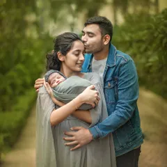 A new family of three, wrapped in a moment of pure love. The father’s gentle kiss and the mother’s serene expression as she holds their newborn perfectly capture the beginning of their journey.