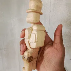 This little traveler was carved from a chip of a tree found lying in the grass. We cleaned him up and gave him a new story, complete with a backpack and a hat.