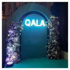 This illuminated 'Qala' entrance arch, flanked by lush floral towers, created a dramatic entryway for the Vespa launch party. The cool blue lighting and dense white flowers provided a high-end, exclusive feel.