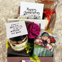 Celebrate your journey together with a romantic anniversary hamper. This gift box is filled with love, featuring sugar-free sweets, a "Happy Anniversary" card, a personal "I Love You to the Moon and Back" note, and other curated items to make your special day even more memorable.