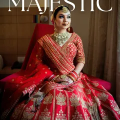 A majestic portrait of the bride sitting in her stunning red lehenga. The makeup features a bold eye and a flawless base, creating a look that is both powerful and elegant.