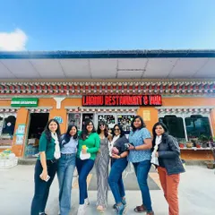 A glimpse of our ongoing trip in Bhutan. A group of women poses in front of a local restaurant, showcasing the fun, food, and friendships we explore in the Himalayan kingdom.
