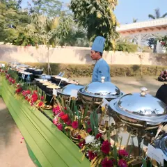 A chef at our outdoor live counter, ready to serve guests. The setup includes a variety of prepped ingredients and sauces, allowing for customized dishes made to order.