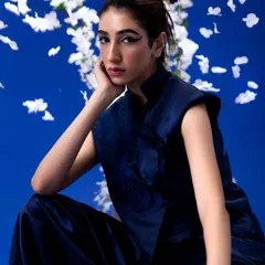 A Japanese-inspired "Yume" editorial featuring a bold, graphic winged eyeliner and a clean, knotted top-bun. The makeup is sharp and precise to complement the minimalist styling.