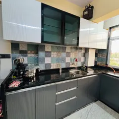 This kitchen features a contemporary look with textured grey base cabinets and glossy white upper cabinets. The patterned tile backsplash adds a touch of Moroccan flair.
