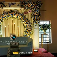 An elegant cradling ceremony stage with a beautiful floral arch against a clean white backdrop. The simple yet sophisticated design creates a serene and celebratory atmosphere.
