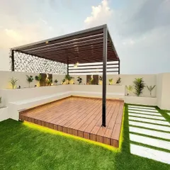 We built this expansive terrace retreat to be both beautiful and practical. The design features a sleek black pergola over a raised wooden deck, surrounded by durable artificial grass that stays green all year. The built-in bench seating provides ample space for guests, while the stone pathway adds a touch of elegance to the outdoor garden design.