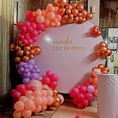 A colorful and chic decoration for a 31st birthday. This setup uses a custom backdrop panel and a balloon arch with a beautiful blend of pink, purple, and rose gold chrome balloons.