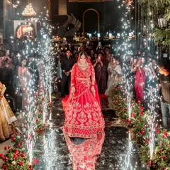 A spectacular bridal entry on a reflective aisle lined with cold pyrotechnics. This photo captures the grandeur and magic of the moment she walks towards her future.