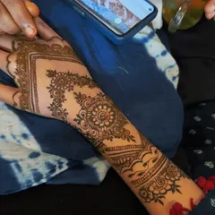 This photo captures me in action, creating a custom floral and mandala design for a client. You can see the reference photo on the phone, showing how I can replicate or adapt designs you love.