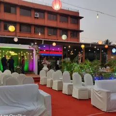 This is a wide view of an outdoor venue I decorated. You can see the guest seating arrangement with white covers, the main stage, and the hanging paper lanterns that create a festive mood for an evening event.