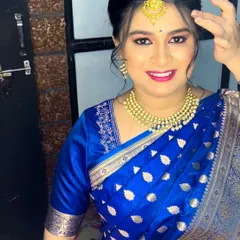 An elegant and subtle makeup look for a wedding guest. The focus is on flawless skin and a pretty pink lip, paired with a beautiful blue Banarasi saree.