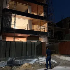 Here I am observing the facade of the Noida house as exterior work continues. The combination of dark cladding and a perforated screen creates a unique texture.