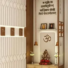 This pooja unit combines modern design with traditional elements. It features a Gayatri Mantra inscription, hanging temple bells, and a clean, light-wood cabinet for storing pooja essentials.