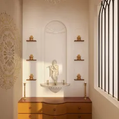 Inside the puja room, the mandir is designed with an arched niche that mirrors the entryway. Small shelves hold brass idols, and a beautiful mandala stencil on the wall adds a spiritual and artistic element.