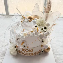 I designed this cake for a studio relaunch, focusing on a modern and luxurious feel. It's all about the details: the clean white finish, gold accents, delicate ribbons, and a mix of textures.