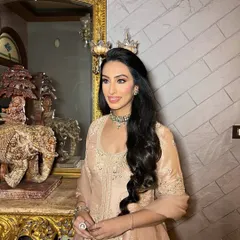 A full shot of the bride-to-be, her elegant pastel outfit complemented by luminous skin and sculpted features.