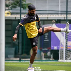 A player warms up with stretches on the turf. The quality of the venue and playing surface is something I always guarantee for a professional tournament experience.