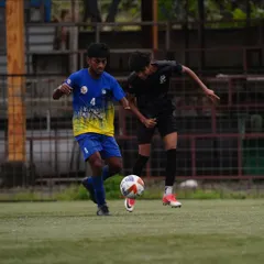 A tense 1v1 situation on the wing, with our player shielding the ball effectively under pressure from the defender.