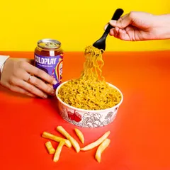 An action shot of noodles being lifted from a bowl, with fries and a drink on the side. The vibrant, color-blocked background makes this perfect for a fun, youthful brand.