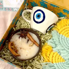 A closer look at the details in my Nurture and Protection hamper. The coconut shell candle is infused with spices like star anise and cinnamon, and the evil eye mug is handcrafted, making each piece unique.