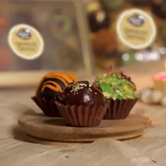 The hazelnut truffle, a classic favorite, is topped with a sprinkle of gold leaf for a touch of luxury. All our truffles are handcrafted to perfection.