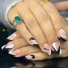 A striking geometric design with black, white, and nude color-blocking on long, square-shaped nails for a modern and edgy look.