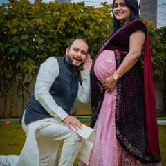 A playful and heartwarming studio shot. The dad-to-be leans in to listen to the baby bump, a classic pose that captures the excitement of waiting to meet their little one.