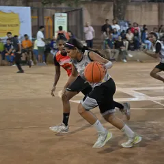 Fierce competition in our women's division. A player drives past the defense for a tough layup, showcasing the skill and intensity of our women's games.