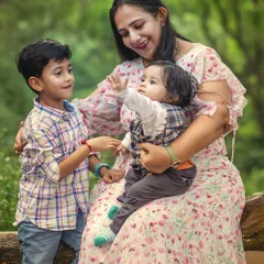 A mother sits on a log in the woods, sharing a tender moment with her two young sons. This portrait showcases the warmth and connection that unfolds naturally during my outdoor sessions.
