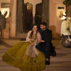 A romantic evening shoot with a beautiful couple. He is wearing a dark, modern suit that perfectly complements her vibrant gown, creating a moody and stylish look.