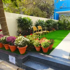 Another view of the charming garden seating area, highlighting the mix of potted seasonal flowers and permanent shrubs.
