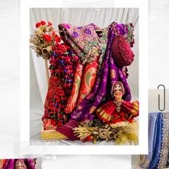 A vibrant and traditional Teej Sinjara hamper. This arrangement features brightly colored fabrics, including a purple bandhani saree, accented with red floral details and a classic fan for a truly festive presentation.