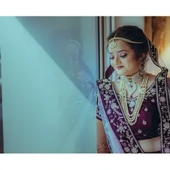 A moment of quiet reflection for the bride before the ceremony begins. The soft light from the window creates a gentle and dreamy mood.