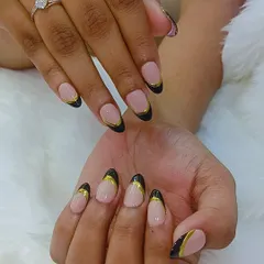A chic and sophisticated design. This set features a sheer nude base with black French tips outlined in a delicate gold line.