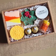A festive Diwali hamper packed with handmade goodies. This set includes a colorful layered soap, a decorative candle, ubtan, bath salts, and chocolates, making it a complete gift.