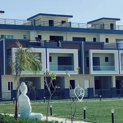 A closer look at the facade of the row housing units in Kanpur. Each unit features a distinct framed balcony and a mix of materials, providing individuality within a cohesive architectural language for the entire community.