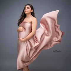 A whisper of satin and a gentle breeze create this stunning, glamorous portrait. The soft pink fabric beautifully complements the mother's radiant glow.