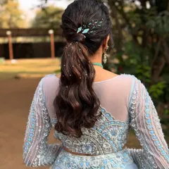 A stylish and modern ponytail with soft waves, perfect for a cocktail party or reception. The look is elevated with sparkling hairpins.