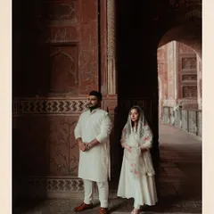 A regal portrait inside the beautiful archways of the Taj Mahal complex. The rich red stone and intricate architecture create a stunning frame for this elegant pre-wedding photo.