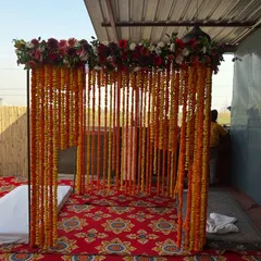 A traditional wedding mandap created with strings of fresh marigold flowers. This open-air setup is perfect for a daytime wedding ceremony, giving it a classic and authentic feel.