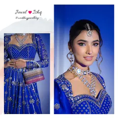 A modern and striking look featuring a layered Polki necklace set against a vibrant royal blue lehenga. This set includes a choker, a longer necklace, matching earrings, and a maang tikka.