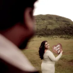 An artistic shot taken over the shoulder of the dad-to-be, focusing on his partner as she smiles back at him. It creates a sense of intimacy and a shared secret.