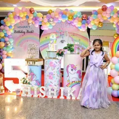 The birthday girl posing with her name in marquee letters and a large light-up number '5'. These props are perfect for photos and add a personalized touch to any theme.