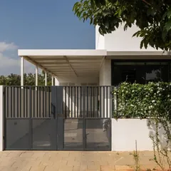 The entrance gate and veranda, showcasing the clean lines and functional design. The covered veranda provides a shaded transition space, protecting the interior from direct sun and rain.