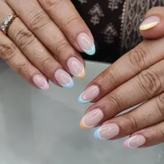 Another view of the popular pastel rainbow French tips. This design works beautifully on natural, well-shaped nails for a clean and modern look.