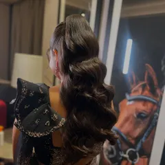 A back view of the voluminous ponytail, showcasing the healthy shine and perfect waves of the hair.