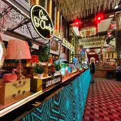 A full view of our expansive, multi-station bar with a vibrant, animated LED facade. This setup includes dedicated areas for different spirits, like the 'Gin O'Clock' station, ensuring a dynamic and engaging experience for all guests.