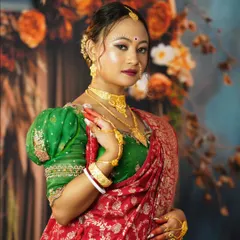 A close-up of the Bengali bride, highlighting the classic makeup with a prominent bindi and traditional gold jewelry.