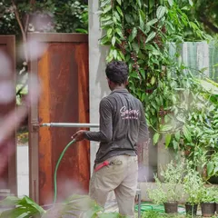 It's the quiet, consistent care that keeps a space alive. A team member watering the garden is a daily ritual that ensures every plant gets the hydration it needs, preserving the calm and beauty of the landscape.